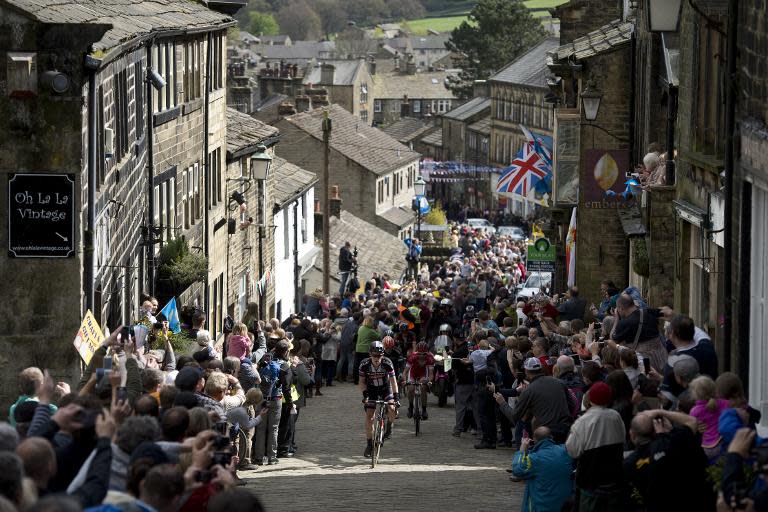 Cylists ride on a cobblestone street through the village of Haworth as they take part on the third and final day of the inaugural Tour de Yorkshire in Haworth on May 3, 2015