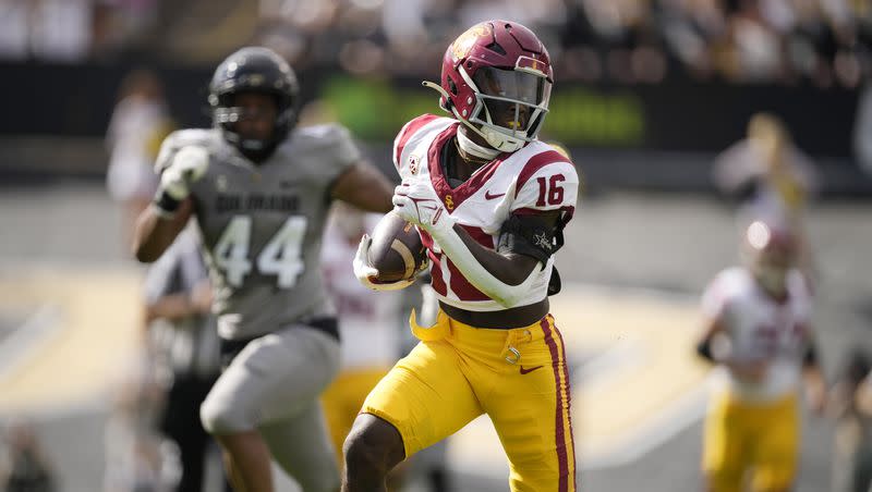 Southern California wide receiver Tahj Washington, front, runs for a touchdown after pulling in a pass as Colorado linebacker Jordan Domineck pursues in the first half of an NCAA college football game Saturday, Sept. 30, 2023, in Boulder, Colo.