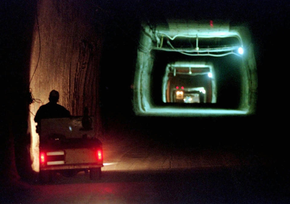 FILE - In this April 8, 1998, file photo, a worker drives a cart through a tunnel inside the Waste Isolation Pilot Plant No. 2, 150 feet below the surface near Carlsbad, N.M. Twenty years and more than 12,330 shipments later, tons of Cold War-era radioactive waste from decades of bomb-making and research have been stashed in the salt caverns that make up the underground facility and not without issues. (AP Photo/Eric Draper, File)