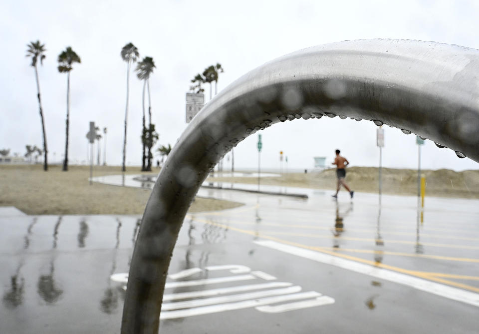 Wet weather is no barrier for joggers along the bike path in Long Beach, Calif., Monday, Oct. 25, 2021. (Brittany Murray/The Orange County Register via AP)