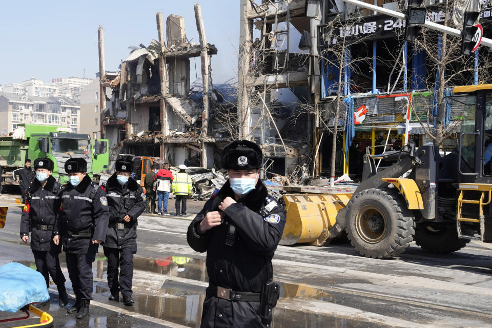 Chinese police officers prepare to clear journalists away from the scene of an explosion in Sanhe city in northern China's Hebei province on Wednesday, March 13, 2024. City officials in eastern China have apologized to local journalists after authorities were shown pushing them and trying to obstruct reporting from the site of a deadly explosion, in a rare acknowledgment of state aggression against journalists. (AP Photo/Ng Han Guan)