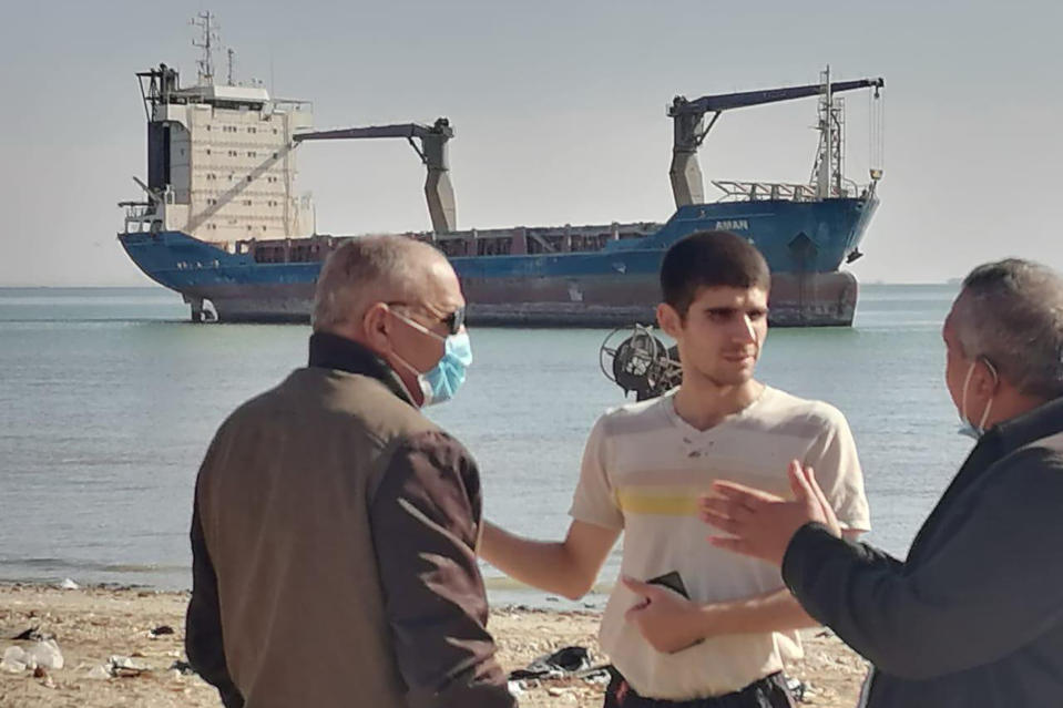 This photo provided by the International Transport Workers’ Federation shows Mohammad Aisha, center, near the abandoned cargo ship MV Aman in Egyptian waters in March 2021. In 2021 reports surfaced that he was living alone on the ship, forced to swim to shore for food and water. Though he left the ship in 2021, the case is still working its way through the courts three years later. He has not yet been paid, the ITF said. (ITF via AP)