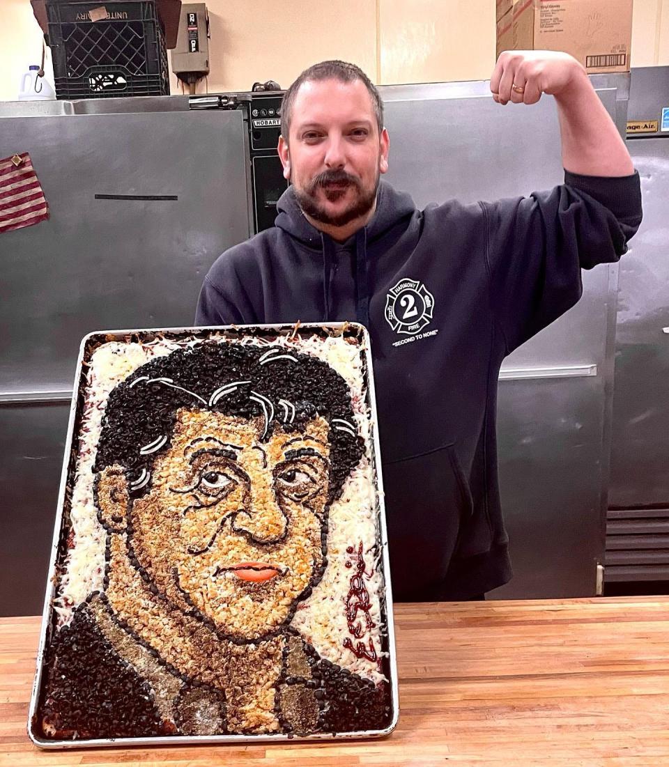 Pizza artist Eric Palmieri, of D. Palmieri's Bakery in Johnston, R.I., shows off his pizza portrait of actor Sylvester Stallone.