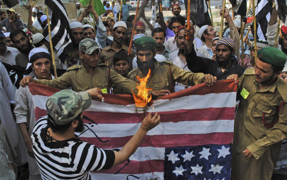 Supporters of Pakistani religious party Jamiat Ulema-e-Islam, burn a representation of a US flag during a rally condemning US drone strikes in tribal areas and the reopening of the NATO supply line to neighboring Afghanistan, in Hyderabad, Pakistan, Friday, June 15, 2012. (AP Photo/Pervez Masih)