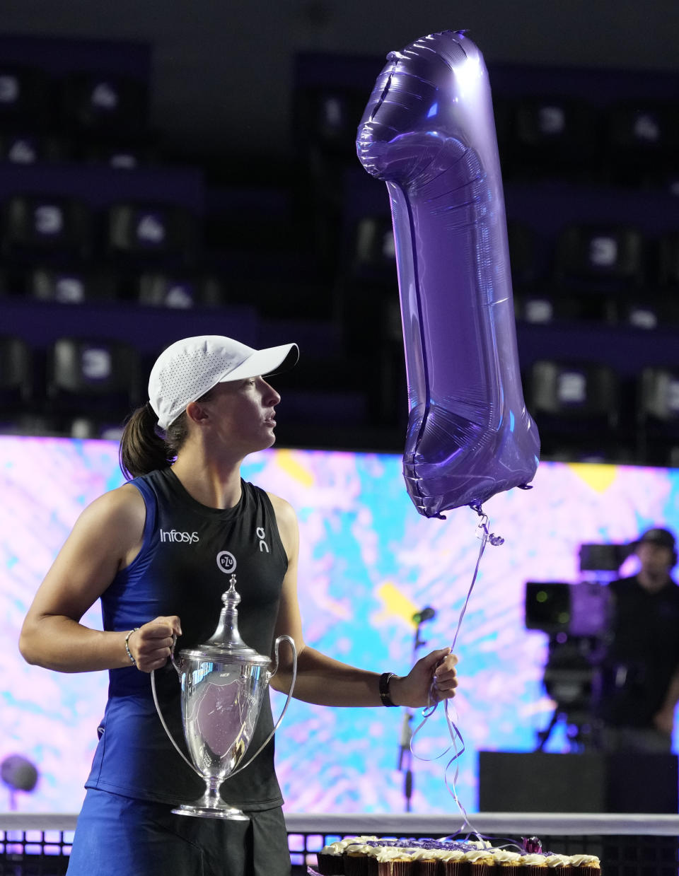 Iga Swiatek, of Poland, holds her trophy and a giant number 1 balloon, after her victory over Jessica Pegula, of the United States, in the women's singles final of the WTA Finals tennis championships, in Cancun, Mexico, Monday, Nov. 6, 2023. (AP Photo/Fernando Llano)