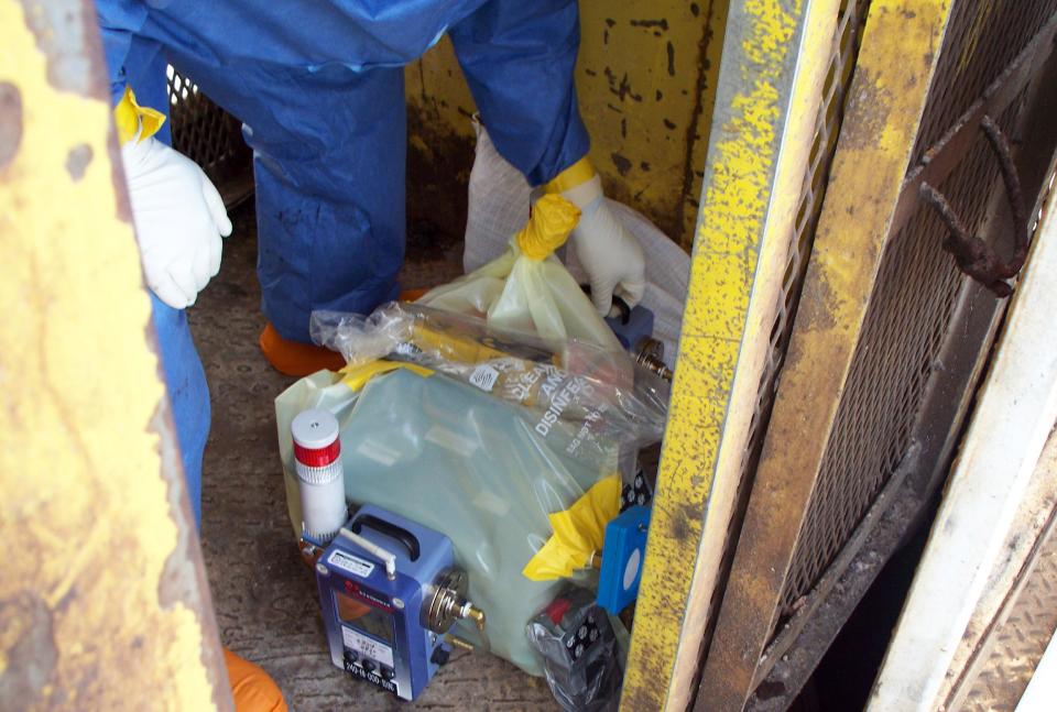 In this March 7, 2014 photo released the U.S. Department of Energy, specially-trained workers place instruments in an elevator to make unmanned tests inside a nuclear waste dump in Carlsbad, N.M. They are finalizing plans to enter the nation's only underground nuclear waste dump after two separate incidents forced its closure weeks ago, including a leak that exposed more than a dozen workers to low levels of radiation. Officials with the DOE's Waste Isolation Pilot Plant say initial testing shows there's no contamination at an air intake shaft that leads into the mine or at the bottom of the mine's salt shaft. (AP Photo/Department of Energy)