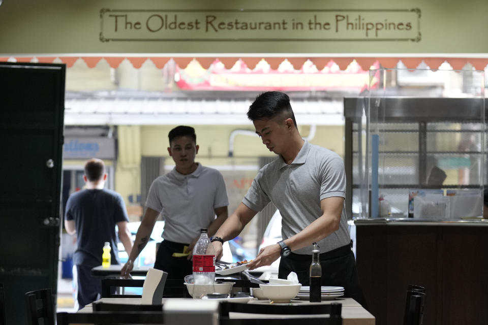 A man arranges dishes at the Toho Panciteria Antigua, one of the few remaining old restaurants in Binondo district, Manila, Philippines, said to be the oldest Chinatown in the world, on Monday, Feb. 5, 2024. Crowds are flocking to Manila's Chinatown to usher in the Year of the Wood Dragon and experience lively traditional dances on lantern-lit streets with food, lucky charms and prayers for good fortune. (AP Photo/Aaron Favila)