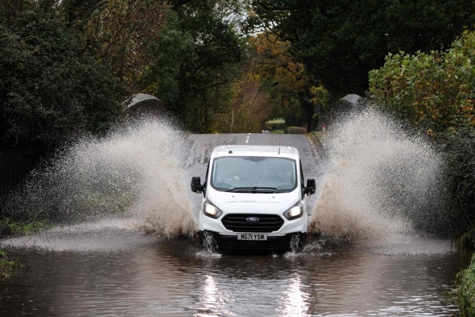 A car drives along a flooded road in Romsey, southern England, on November 2, 2023 as strong winds and heavy rain from Storm Ciaran hits Britain. (AFP via Getty Images)