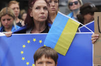 Protestors hold EU and Ukrainian flags during a demonstration in support of Ukraine outside of an EU summit in Brussels, Thursday, June 23, 2022. European Union leaders are expected to approve Thursday a proposal to grant Ukraine a EU candidate status, a first step on the long road toward membership. (AP Photo/Olivier Matthys)