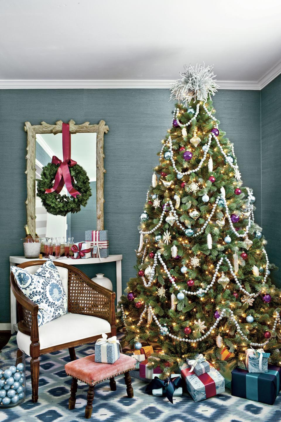 <p>Many of us love to decorate with blue, so why not incorporate it into a holiday palette? "The gorgeous shade of this wallpaper (Jute Grasscloth in Dungaree by Twenty2; <a href="http://twenty2.net" rel="nofollow noopener" target="_blank" data-ylk="slk:twenty2.net" class="link ">twenty2.net</a>) inspired this shimmery tree," says Lindsey. "To offset the rich colors with plenty of sparkle, I piled on the silver—glass ornaments, disco ball-esque garlands, and a quirky topper." <strong><a href="http://www.southernliving.com/home-garden/decorating/christmas-tree-decorations-00417000080582/page12.html" rel="nofollow noopener" target="_blank" data-ylk="slk:Get this look" class="link ">Get this look</a></strong>. </p>