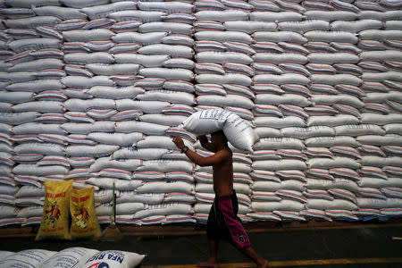 FILE PHOTO: A worker carries on his head a sack of rice inside a government rice warehouse National Food Authority in Quezon city, Metro Manila in Philippines, August 9, 2018. REUTERS/Erik De Castro/File Photo