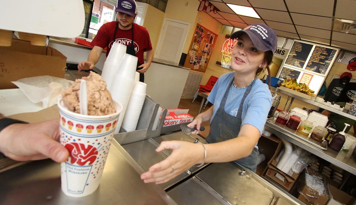 Kenzie Thomas hands a customer their milk shake at Tony’s Ice Cream Tuesday afternoon, July 19, 2022.