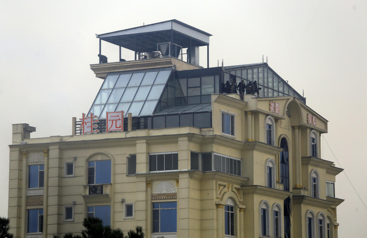 Taliban fighters are seen in the rooftop of a hotel building during a gunfire in the city of Kabul, Afghanistan, Monday, Dec. 12, 2022. A Taliban official says that a hotel building has come under a complex attack in the Afghan capital Kabul. (AP Photo)