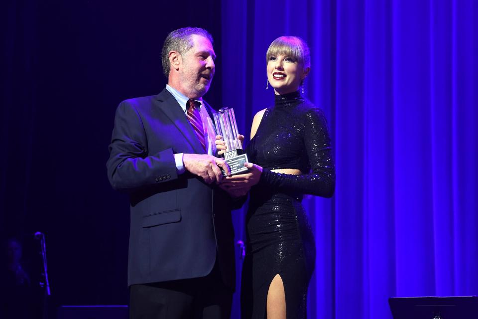 NSAI Executive Director, Bart Herbison presents Taylor Swift with the Songwriter-Artist of the Decade Award onstage