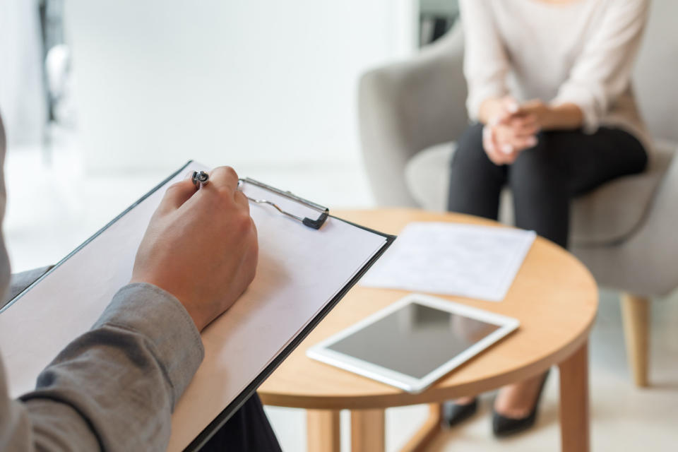 A woman sits with a therapist