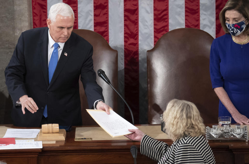 FILE - Vice President Mike Pence hands the electoral certificate from the state of Arizona to Rep. Zoe Lofgren, D-Calif., as he presides over a joint session of Congress as it convenes to count the Electoral College votes cast in November's election, at the Capitol in Washington, Jan. 6, 2021. (Saul Loeb/Pool via AP, File)