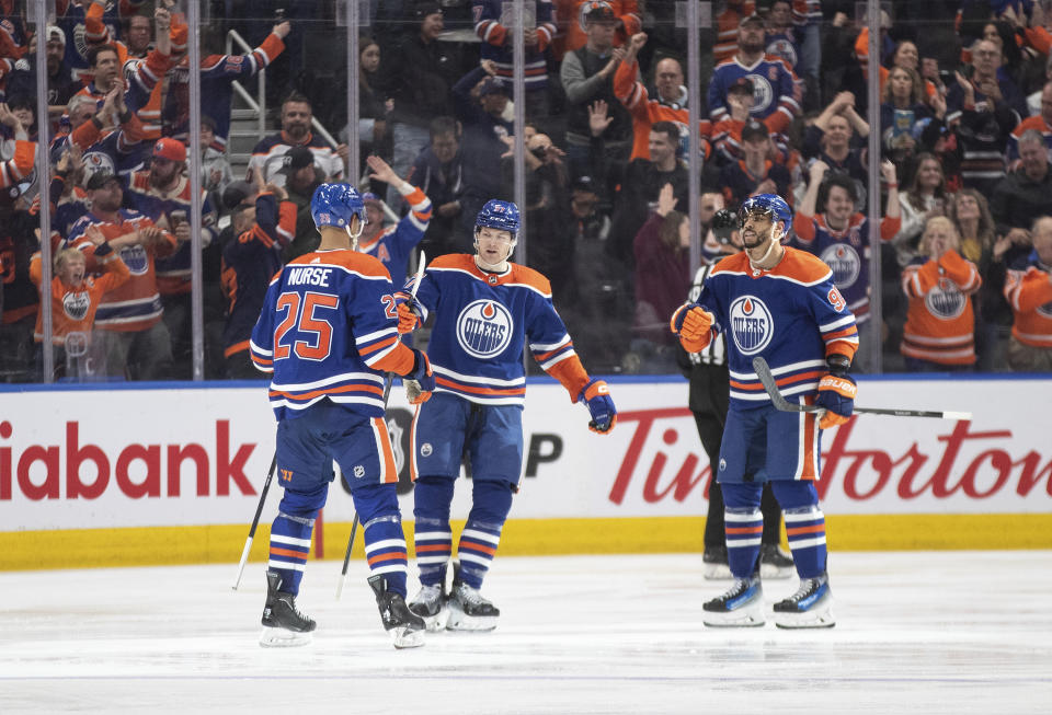 Edmonton Oilers' Darnell Nurse (25), Warren Foegele (37) and Evander Kane (91) celebrate a goal against the Arizona Coyotes during the third period of an NHL hockey game Friday, April 12, 2024, in Edmonton, Alberta. (Jason Franson/The Canadian Press via AP)