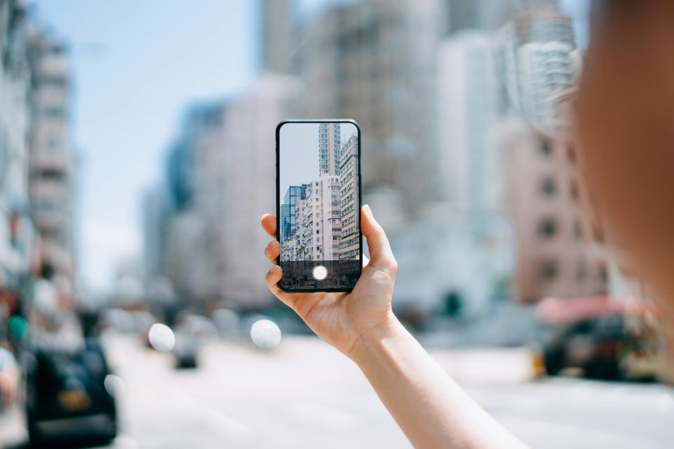 Close-up of a person holding up their phone to take a picture