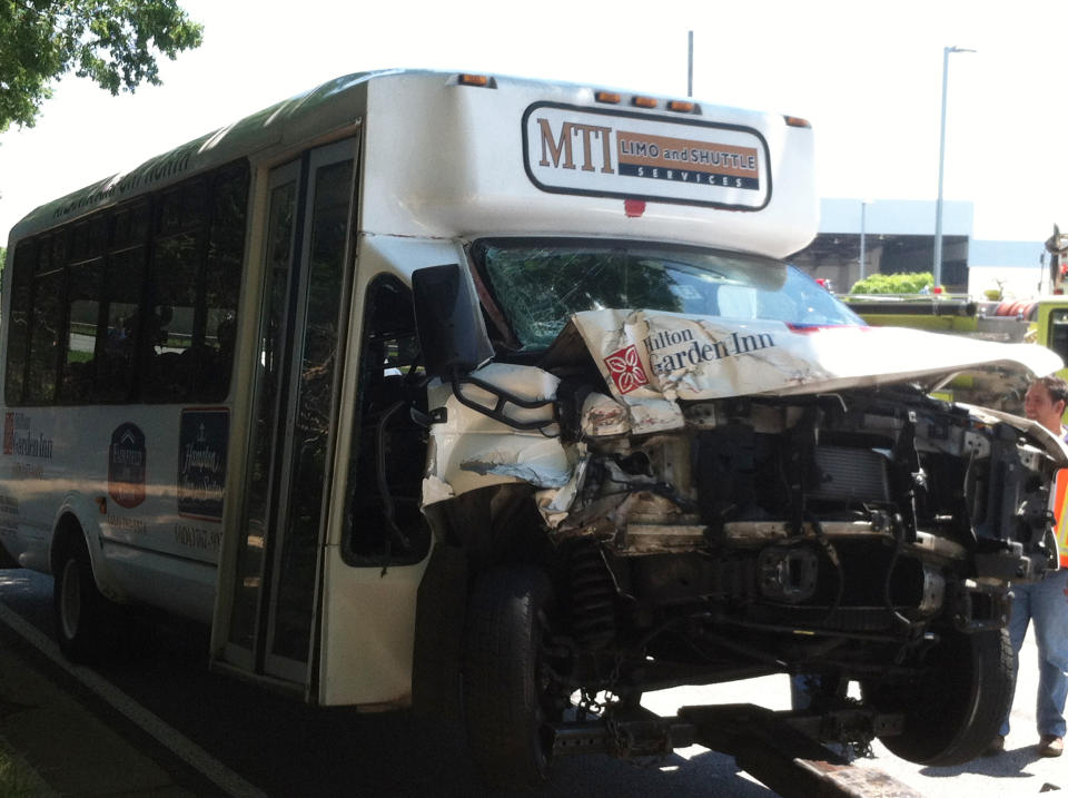 A hotel shuttle bus has it's front end crushed after it crashed with a tractor-trailer on the road that loops around Hartsfield-Jackson Atlanta International Airport, in College Park, Ga., on Friday, May 24, 2013. All 16 people in the crash were taken to area hospitals. None of the injuries are believed to be life-threatening, said Sgt. Keith Stanley. It appears the shuttle struck the side of a tractor-trailer that was attempting a U-turn on the divided road, said Sgt. Stanley. (AP Photo/Ray Henry)