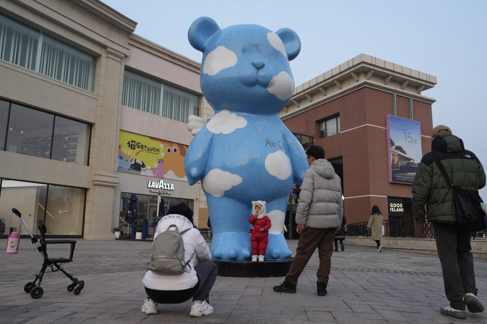 A child poses for a photo outside a shopping mall in Beijing, Saturday, Dec. 30, 2023. China's economy for the Oct-Dec quarter grew at a quicker rate, allowing the Chinese government to hit its annual growth target of about 5% for 2023 even as trade and economic recovery remained uneven. (AP Photo/Ng Han Guan)