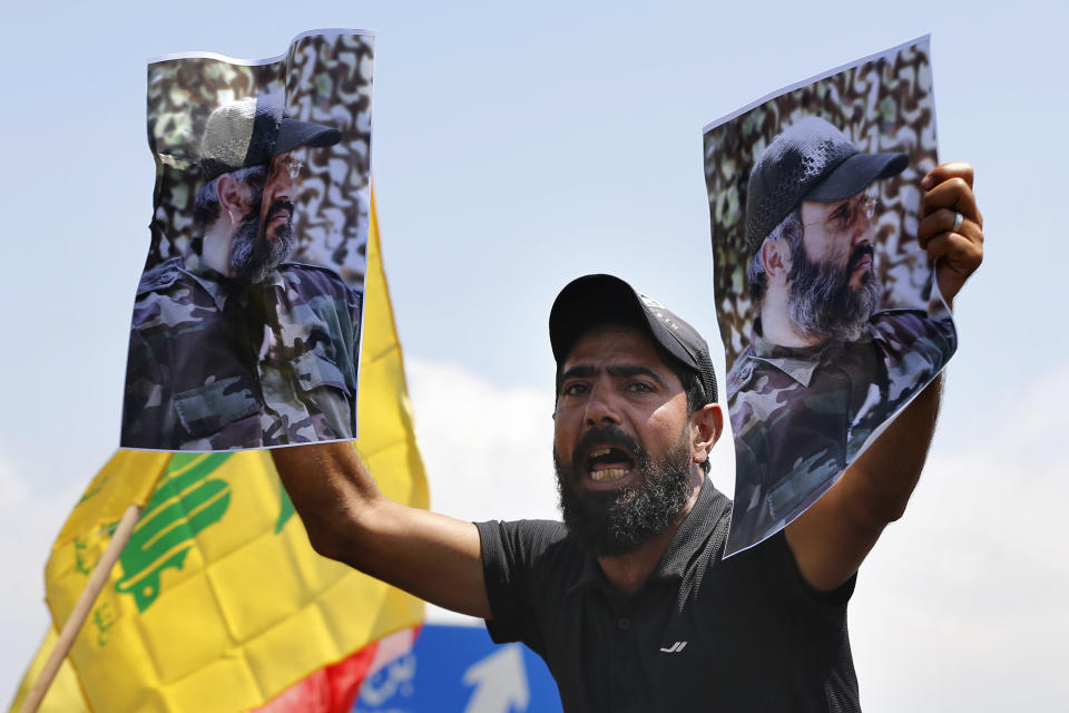A Hezbollah supporter chant slogans and hold posters of the late Hezbollah military commander Imad Mughniyeh, while protesting the visit to Lebanon by Gen. Frank McKenzie, the head of U.S. Central Command, outside ​​the Rafik Hariri International Airport in Beirut, Lebanon, Wednesday, July 8, 2020. (AP Photo/Bilal Hussein)