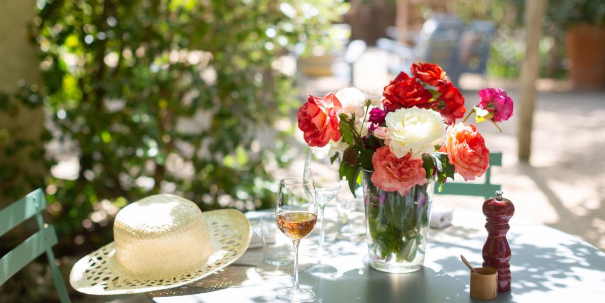 garden table set up with flowers and wine