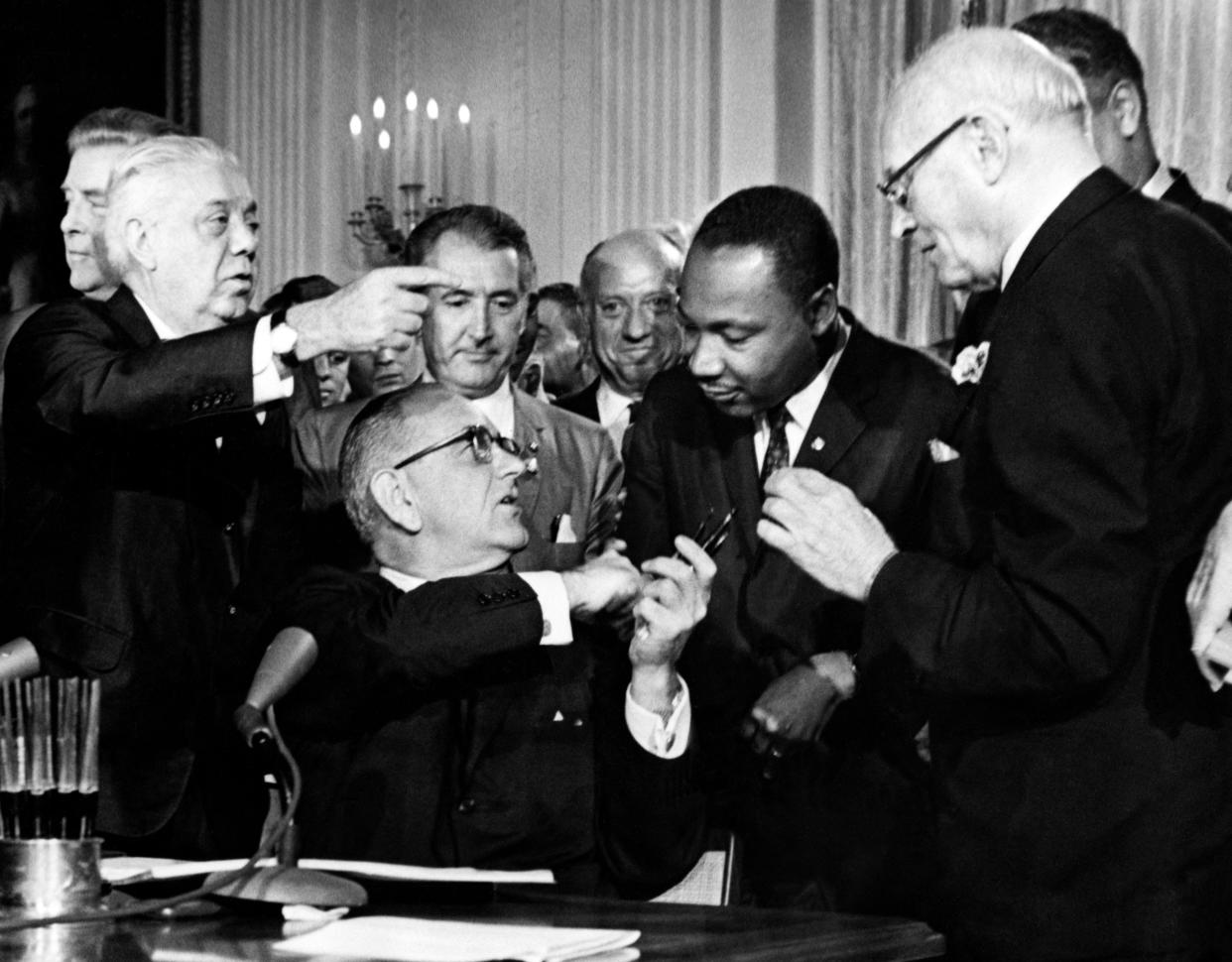 President Lyndon B. Johnson hands a pen to Rev. Martin Luther King after signing the historic Civil Rights Act in the East Room of the White House in Washington, D.C. on July 2, 1964.