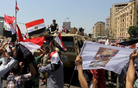 People cheer in front of a military convoy passing by to secure central cairo as Egyptians gather in Tahrir square to celebrate an extension of the Suez Canal, Cairo, Egypt, August 6, 2015. REUTERS/Mohamed Abd El Ghany