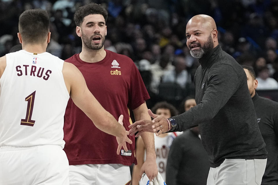 Cleveland Cavaliers head coach J. B. Bickerstaff, right, congratulates guard Max Strus (1) as he comes off the floor for a time out during the second half of an NBA basketball game against the Dallas Mavericks in Dallas, Wednesday, Dec. 27, 2023. (AP Photo/LM Otero)