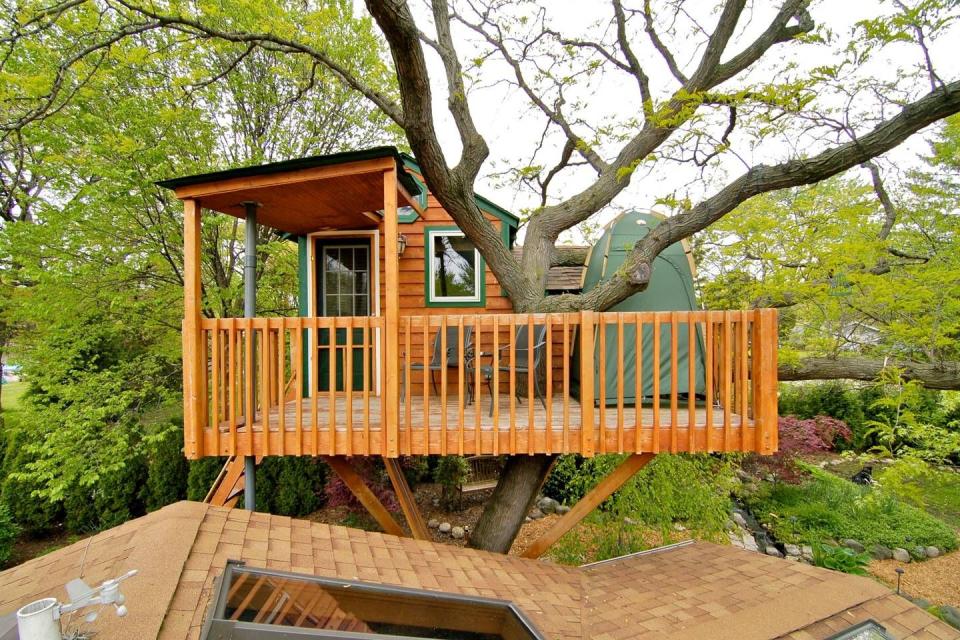 <p>This sturdy cedar structure is located just 30 minutes from downtown Chicago. Perched 15 feet above ground, the treehouse overlooks an enchanting backyard garden, complete with a waterfall and koi pond. Inside, guests are treated to air conditioning as well as a fireplace.</p><p><a class="link " href="https://www.airbnb.com/rooms/440817" rel="nofollow noopener" target="_blank" data-ylk="slk:BOOK NOW;elm:context_link;itc:0;sec:content-canvas">BOOK NOW</a> <strong><em>Enchanted Garden Treehouse</em></strong></p>