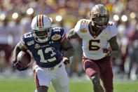 Auburn defensive back Javaris Davis (13) runs with the football after intercepting a pass intended for Minnesota wide receiver Tyler Johnson (6) during the first half of the Outback Bowl NCAA college football game Wednesday, Jan. 1, 2020, in Tampa, Fla. (AP Photo/Chris O'Meara)