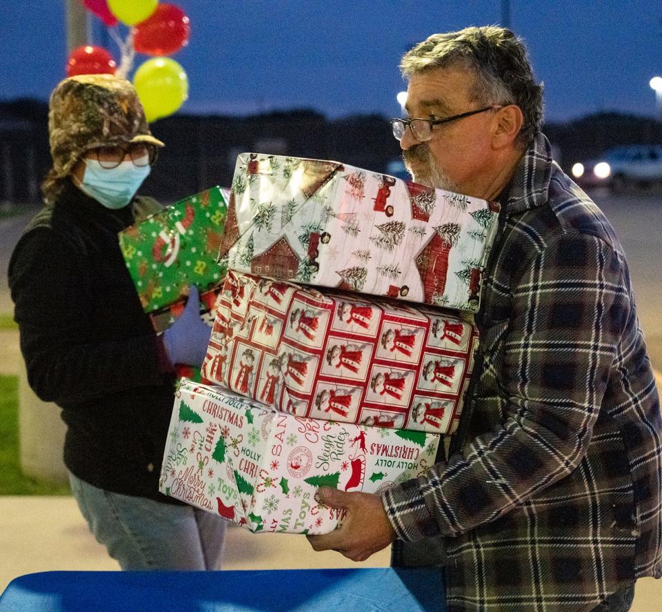 Mauro Rodriguez, right, and Elly Morrison distribute presents for Operation Christmas Gift. “It’s a lot of work, and I’m so thankful to have volunteers come and help me,” organizer Martha Lujan said.