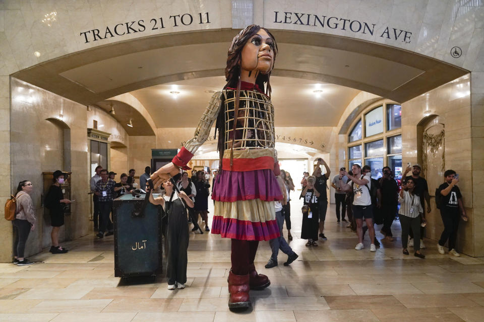 FILE - A 12-foot puppet of a 10-year-old Syrian refuge named Little Amal walks around Grand Central Station in New York, on Sept. 15, 2022. Little Amal will journey across the United States this fall, visiting key places in America’s history in an attempt to raise awareness about immigration and migration.(AP Photo/Seth Wenig, File)