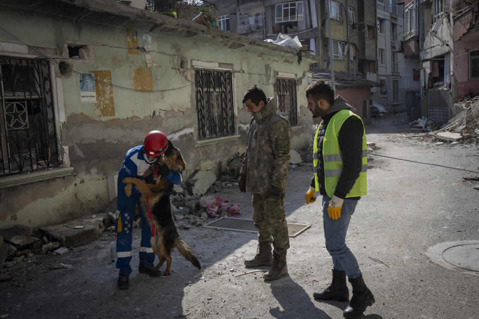 Mehmet Gurkan, miembro del grupo turco de protección animal HAYTAP, acaricia a un perro tras rescatarlo de un edificio afectado por un terremoto en Antioquía, en el sureste de Turquía, el domingo 12 de febrero de 2023. El pastor alemán fue rescatado tras pasar siete días en un edificio afectado por un terremoto. (AP Foto/Bernat Armangué)