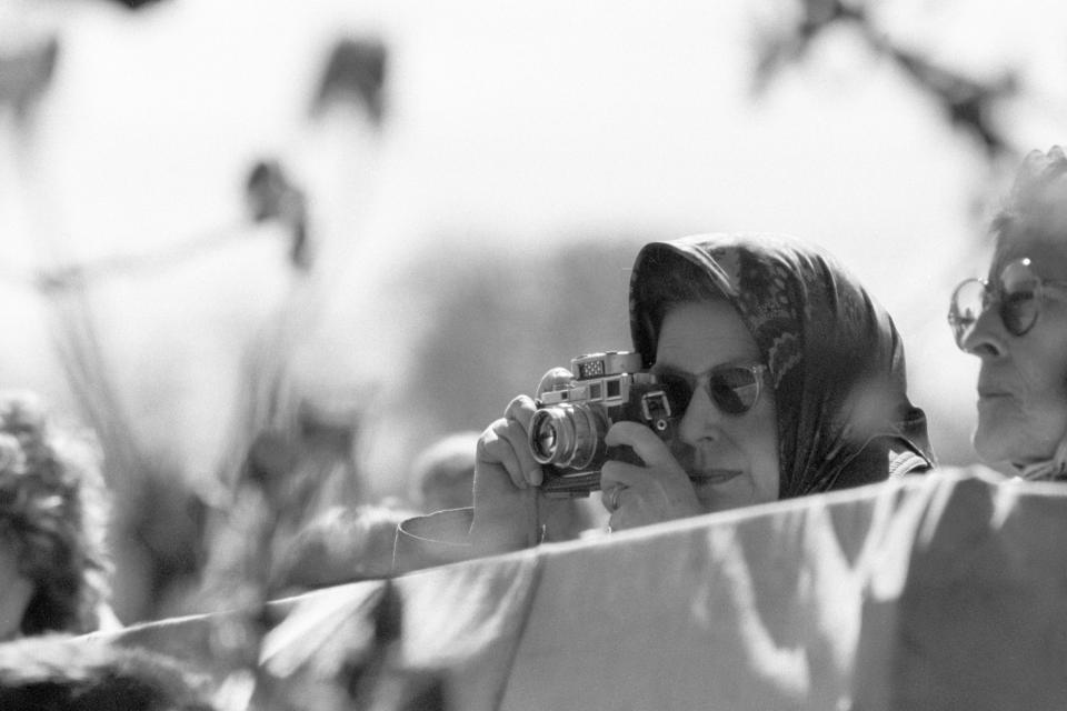 <p>The Queen takes a picture at the Badminton Horse Trials. (PA Archive) </p>