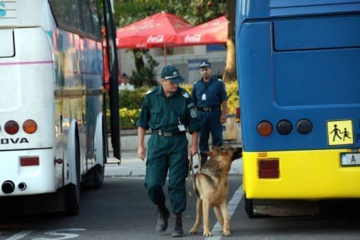 A Bulgarian policeman with a sniffer dog check for explosives buses after an explosion at Bourgas airport. An explosion ripped through a bus carrying Israeli holiday-makers in Bulgaria and killed at least six people on Wednesday in an attack the government in Israel blamed on arch foe Iran