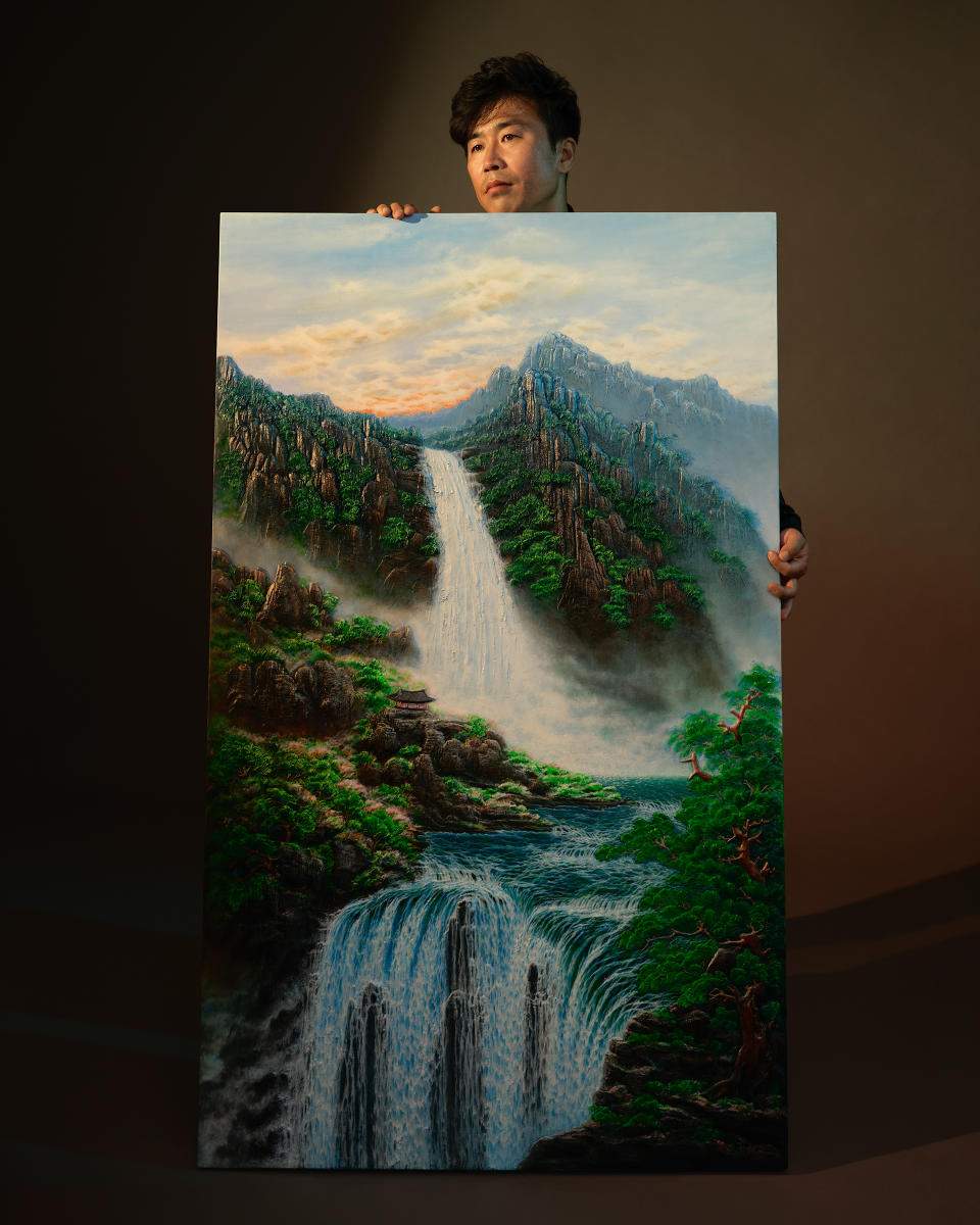 Artist Surl Lee, photographed alongside his artwork on Sept. 9. Lee says what he misses most about North Korea are the beautiful waterfalls.<span class="copyright">Catherine Hyland for TIME</span>