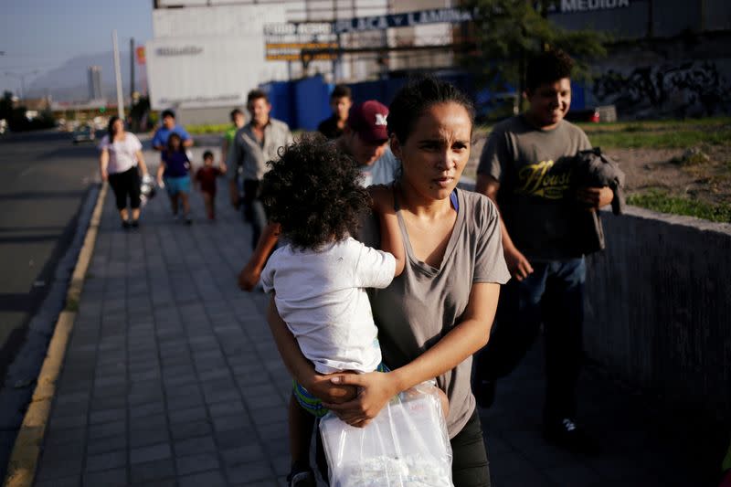 FILE PHOTO: Central American migrants, returned from the U.S. to Nuevo Laredo in Mexico under the Migrant Protection Protocol to wait for their court hearing for asylum seekers, are seen walking towards a shelter after arriving to Monterrey