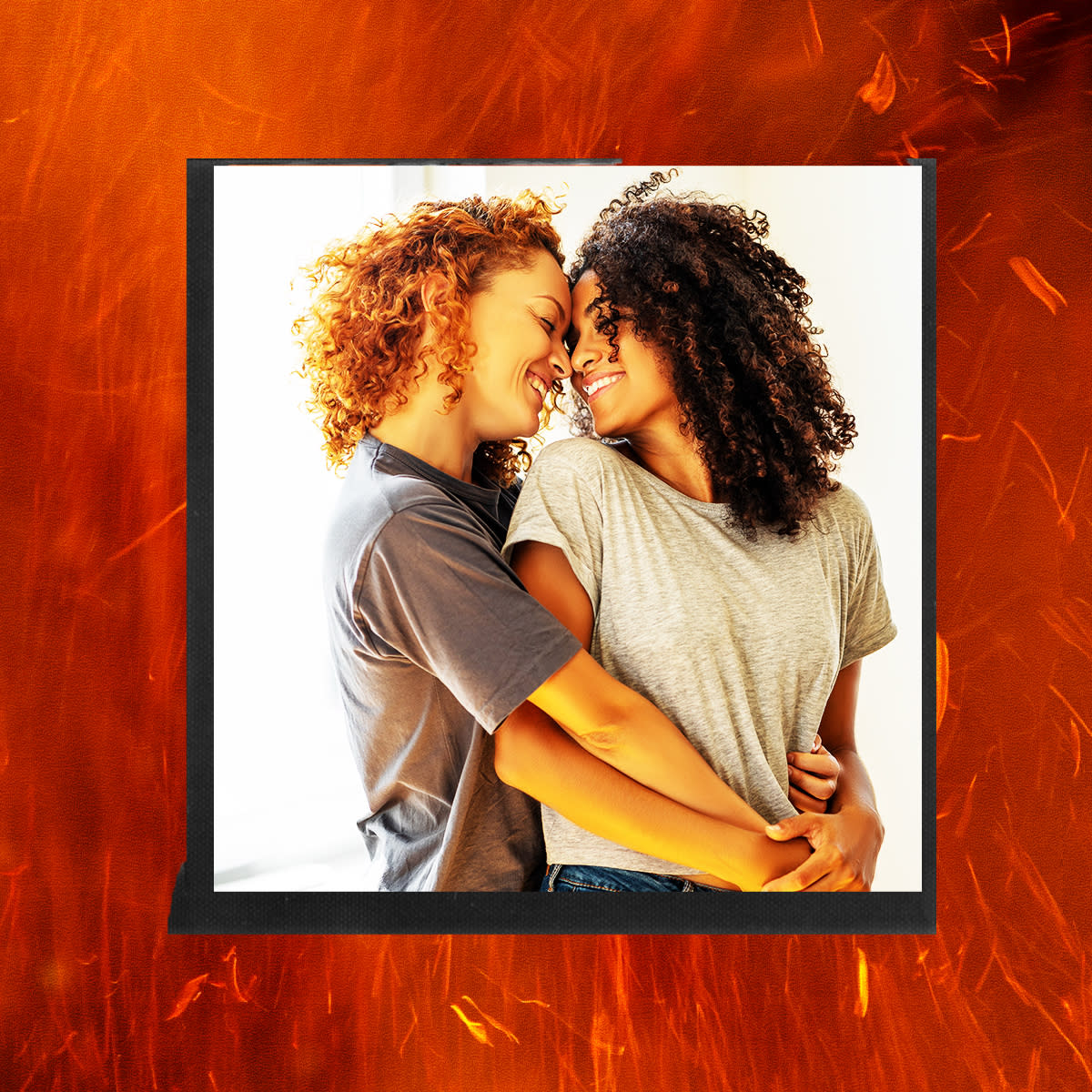  women embracing with backdrop of fire 