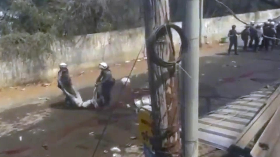 In this March 3, 2021 image from video obtained by The Associated Press, police carry the body of someone who witnesses say was shot by security forces in Monywa, Myanmar. Since the military seized control of Myanmar in a takeover on Feb. 1, more than 825 people have been killed _ well over two times the official tally _ according to watchdog group Assistance Association for Political Prisoners. (AP Photo)