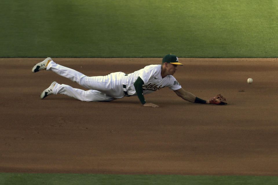 Oakland Athletics' Jake Lamb dives for a single hit by Seattle Mariners' Joseph Odom during the third inning of the second baseball game of a doubleheader in Oakland, Calif., Saturday, Sept. 26, 2020. (AP Photo/Jed Jacobsohn)