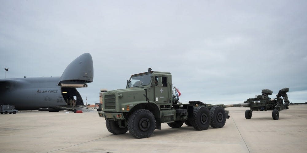 Equipment Operator 3rd Class Donovan Reyes, assigned to Naval Mobile Construction Battalion (NMCB) 1, operates a Medium Tactical Vehicle Replacement to tow a U.S. Army M777 howitzer from a U.S. Air Force C5M Super Galaxy during an embarkation operation.