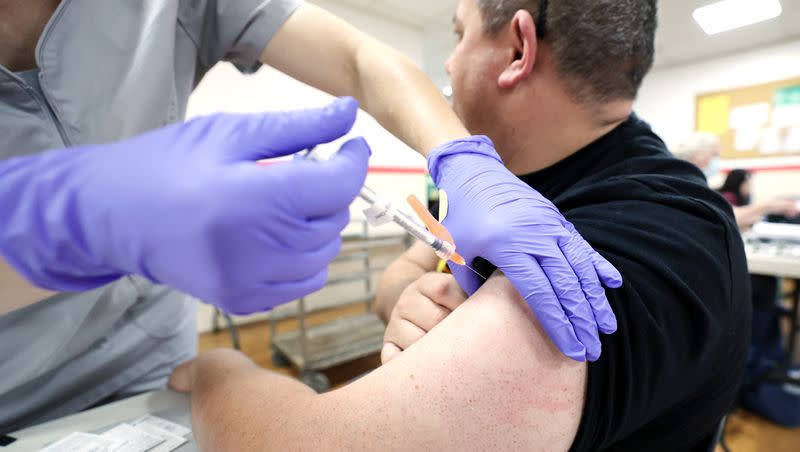 Valorie Mitchell, a paramedic with the Salt Lake County Health Department, gives Jason Mettmann a vaccination during a free COVID-19 vaccination and testing clinic at the Tongan Methodist Church in West Valley City on Oct. 15, 2022.