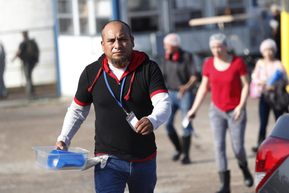 Koch Foods Inc., employees leave their Morton, Miss., plant following a immigration raid Wednesday morning, Aug. 7, 2019. The early morning raids were part of a large-scale operation targeting owners as well as undocumented employees. (AP Photo/Rogelio V. Solis)