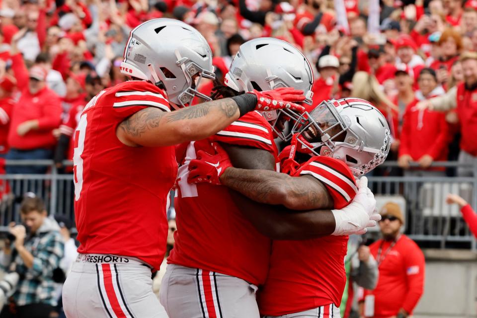 Ohio State running back Miyan Williams, right, celebrates his touchdown with teammates Cade Stover, left, and Donovan Jackson.