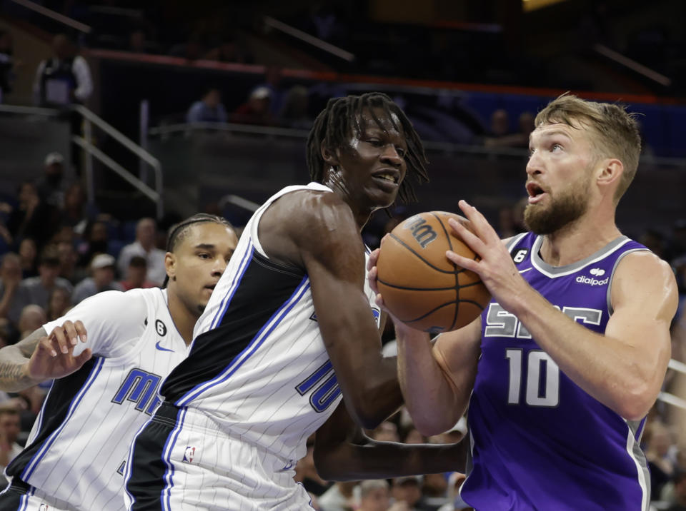 Sacramento Kings forward Domantas Sabonis (10) goes up for shoot against Orlando Magic center Bol Bol (10) and Orlando Magic forward Chuma Okeke (3) during the first half of an NBA basketball game, Saturday, Nov. 5, 2022, in Orlando, Fla. (AP Photo/Kevin Kolczynski)