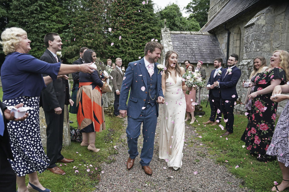 Newly married couple, Lucy and James Bone, celebrate after their wedding at St Michael and all Angels Church as weddings were permitted to take place in the country with ceremonies capped at a maximum of 30 guests, in Ingram, England, Saturday July 4, 2020. England is embarking on perhaps its biggest lockdown easing yet as pubs and restaurants have the right to reopen for the first time in more than three months. (Owen Humphreys/PA via AP)