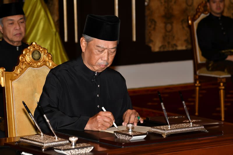 Muhyiddin Yassin signs a document during swearing-in ceremony as Malaysia's prime minister in Kuala Lumpur, Malaysia
