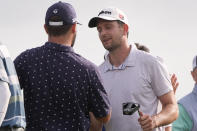 Chad Ramey, left, shakes hands with teammate Martin Trainer after being eliminated in a playoff against Rory McIlroy, of Northern Ireland, and Shane Lowry, of Ireland, finishing second in the PGA Zurich Classic golf tournament at TPC Louisiana in Avondale, La., Sunday, April 28, 2024. (AP Photo/Gerald Herbert)