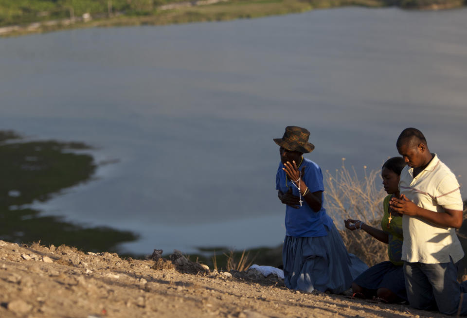 In this Feb. 8, 2014 photo, Christian pilgrims kneel in prayer on top of a mountain during a weekend gathering by Catholics in the village of Bois-Neuf, Haiti. The 2010 earthquake that killed tens of thousands of people and displaced 1.5 million others was on the minds of many pilgrims, and cited as a chief reason to have faith in God. (AP Photo/Dieu Nalio Chery)